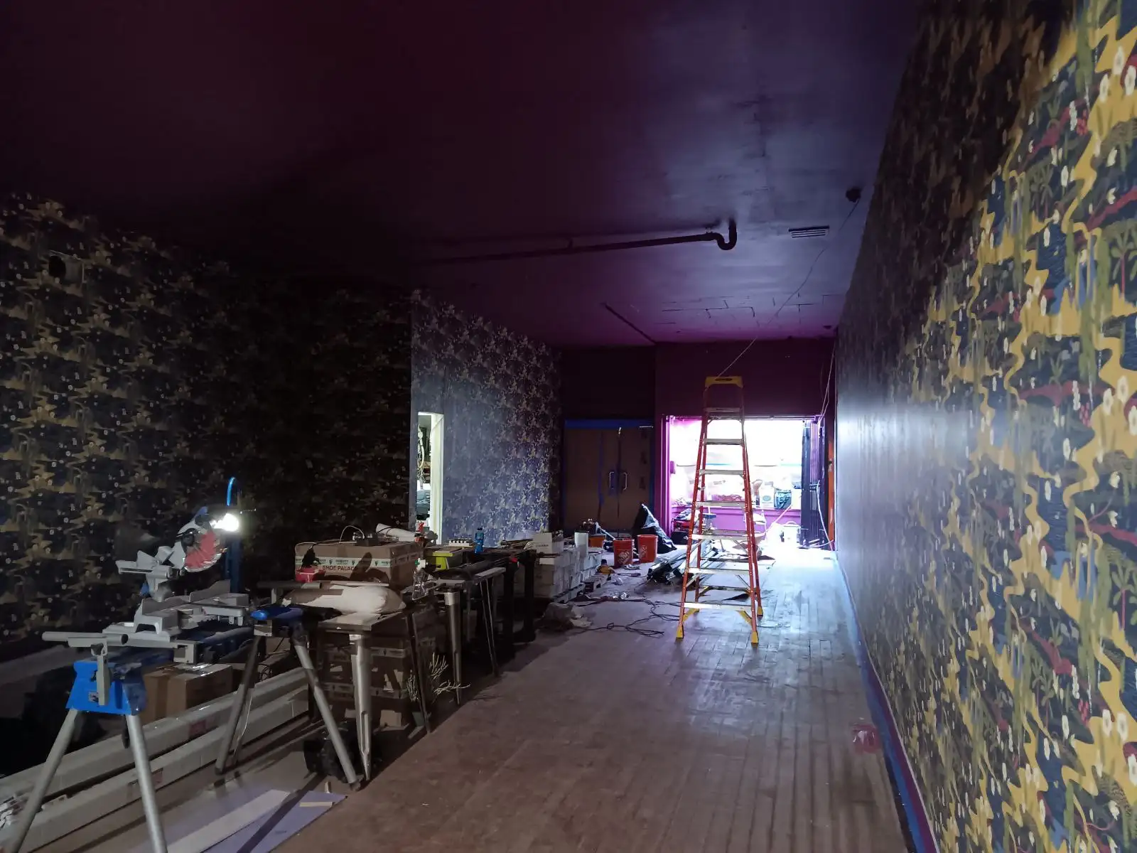 Wallcovering work area with a ladder, tools, and material supplies.